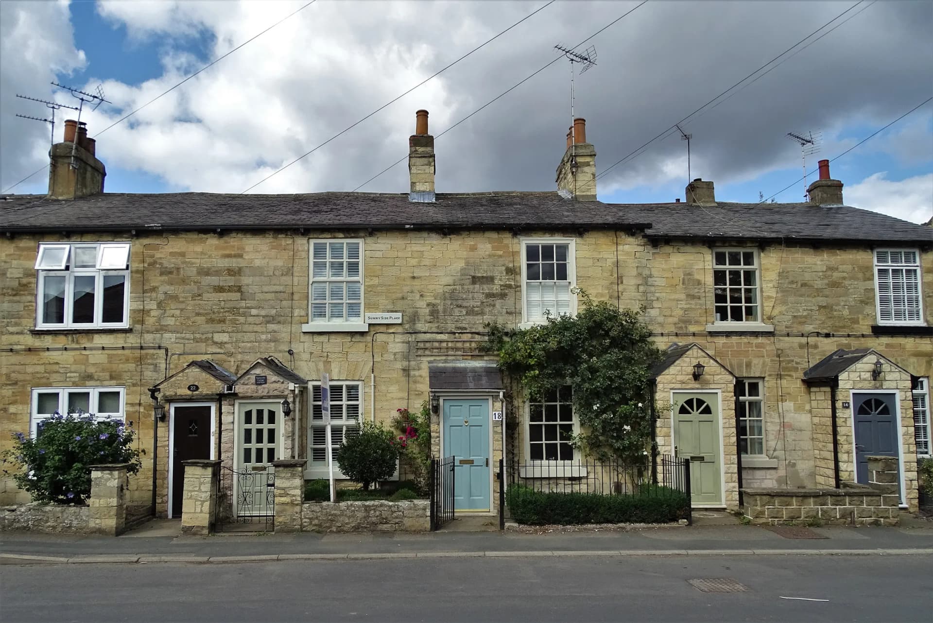 A terrace of stone cottages with painted front doors